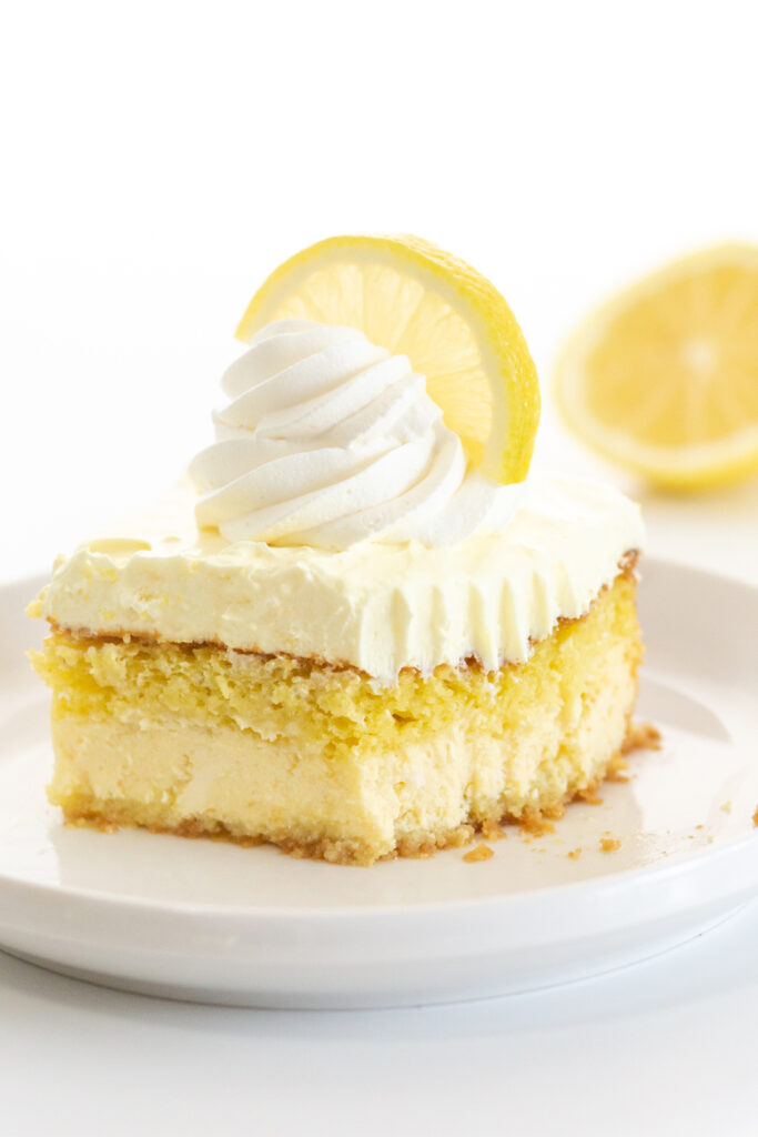 up close slice of layered lemon cake with a fork bite visibly taken out of it.