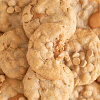 stack of peanut butter cookies stuffed with caramel. halved cookie revealing gooey caramel in the center