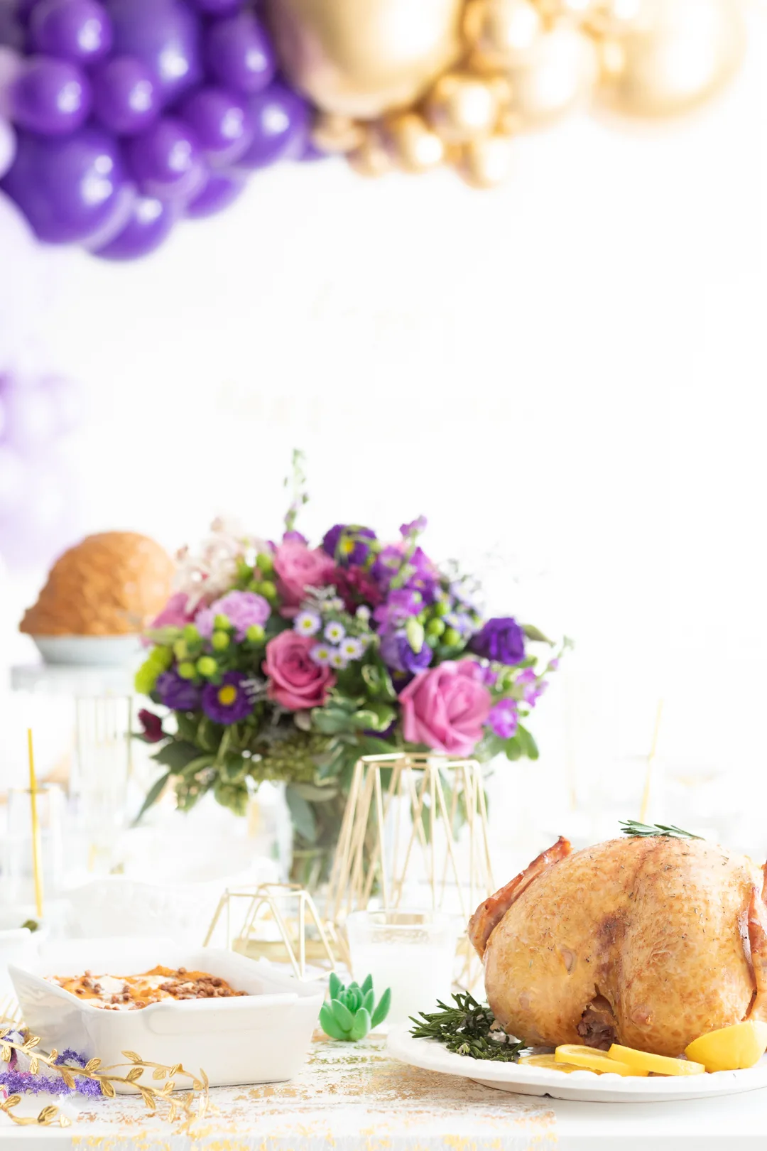 fakesgiving tablescape with traditional thanksgiving foods and trendy purple and gold theme