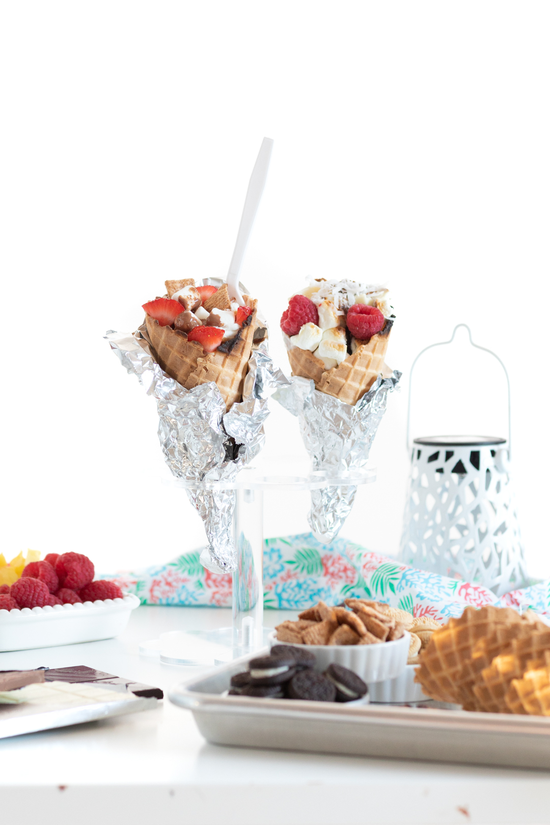 campfire cones resting on an ice cream cone stand, wrapped in foil.  Filled with chocolates, fruits and mini marshmallows.