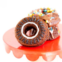 up close view of chocolate wheel donut with black icing for tread