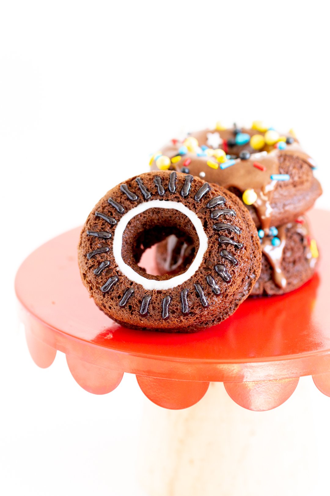 up close view of chocolate wheel donut with black icing for tread