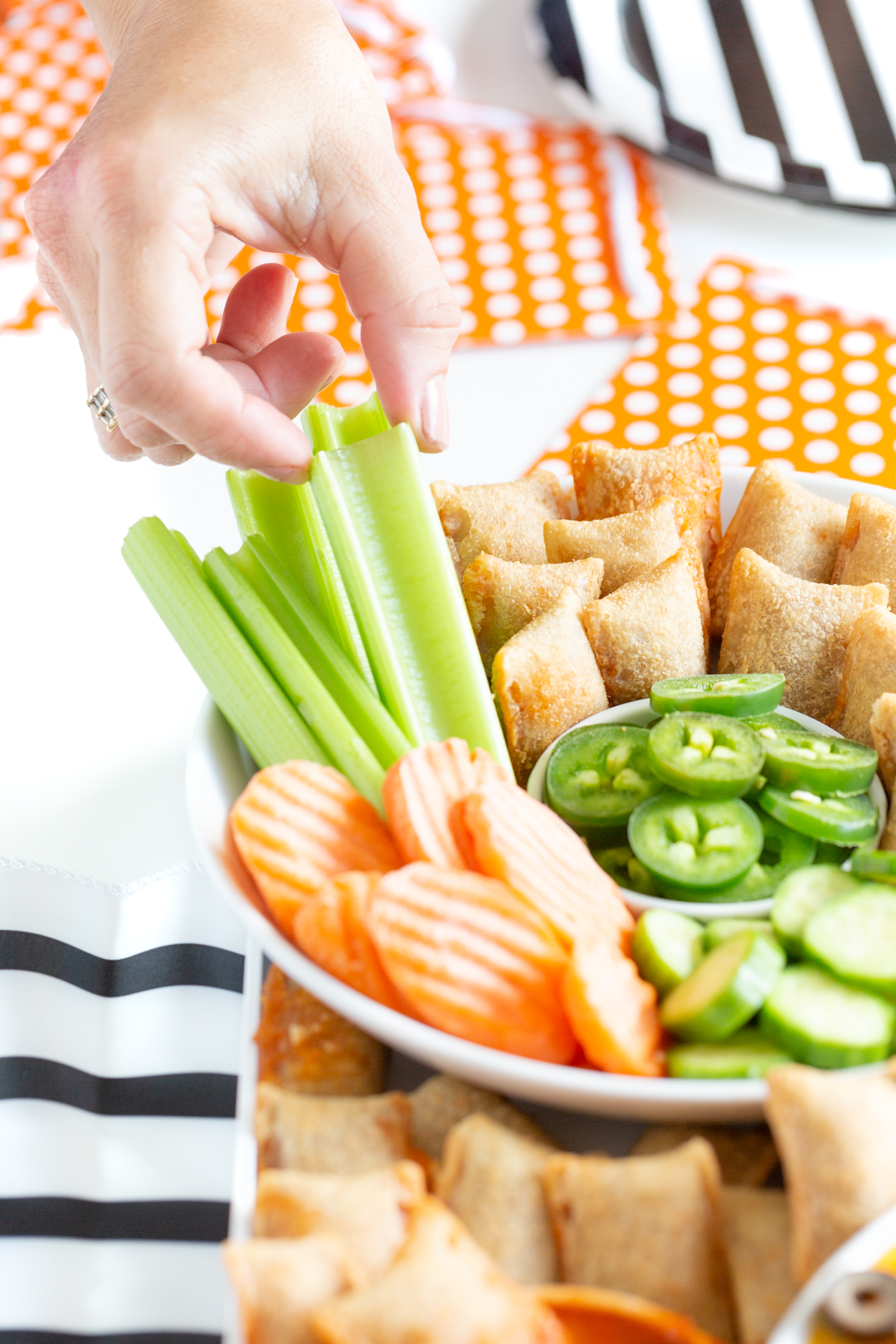 woman grabbing a celery stick from a basketball charcuterie board