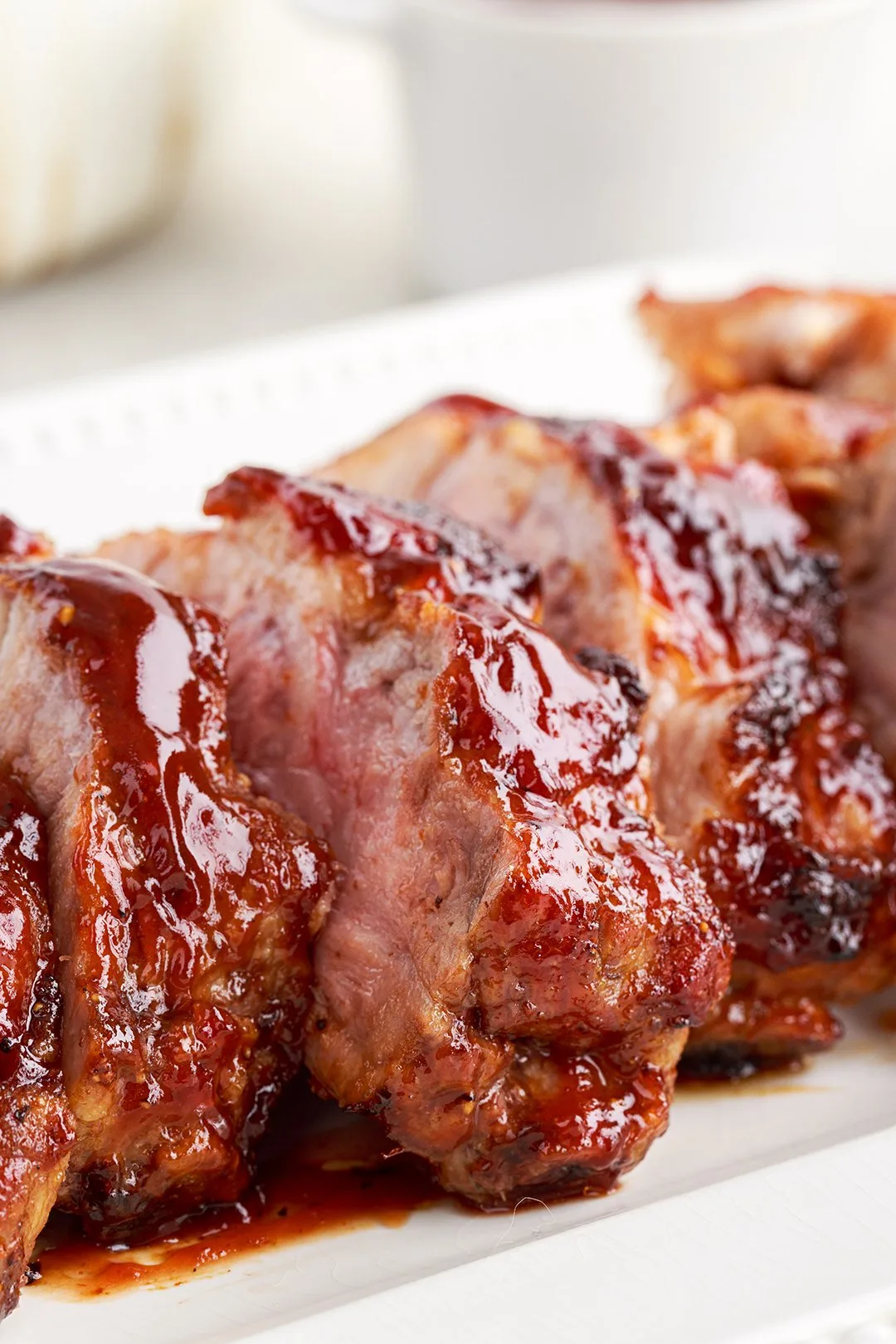 side view of barbecued ribs on a white plate
