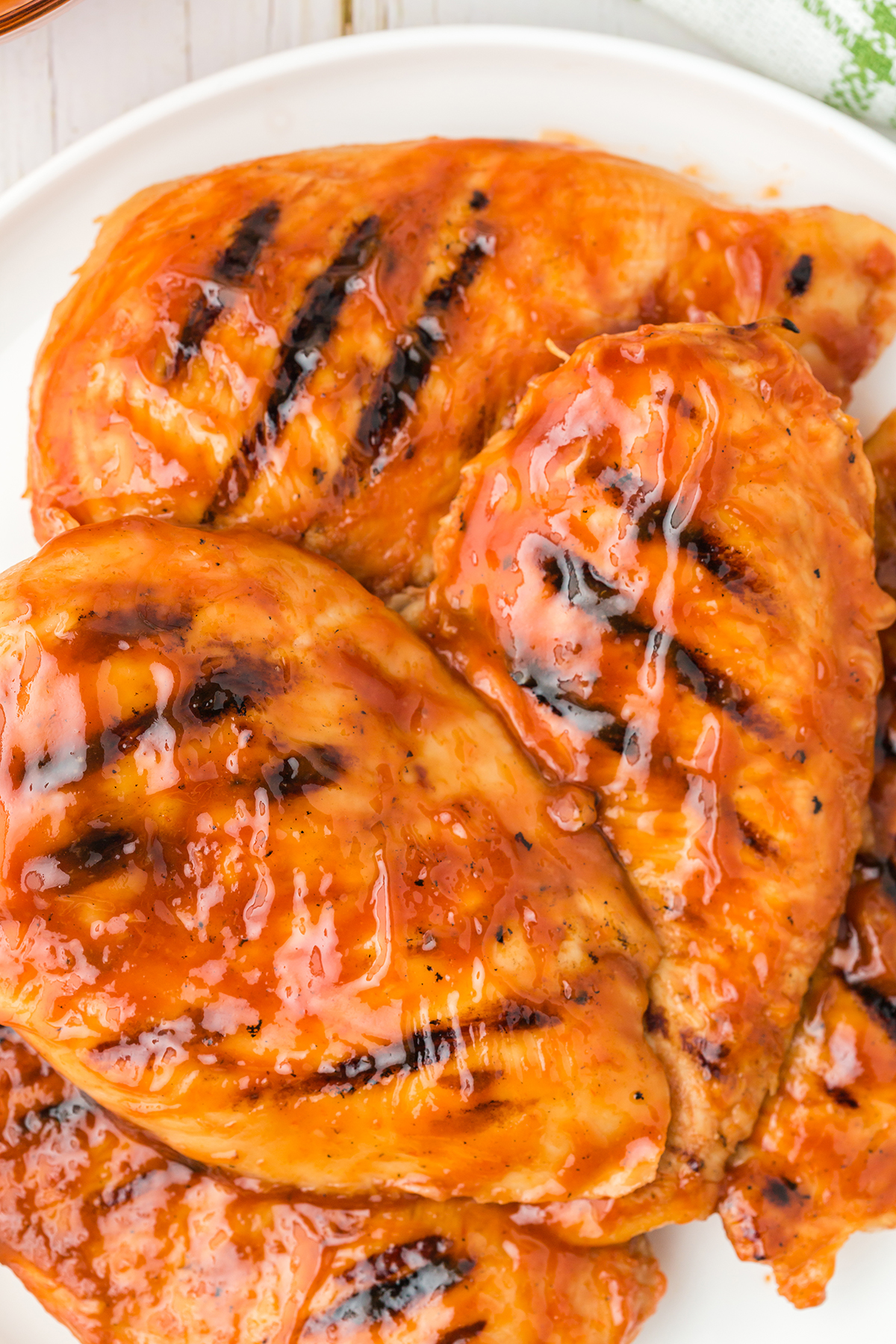 over the top close-up of grilled chicken with gorgeous shiny bbq sauce slathered on top