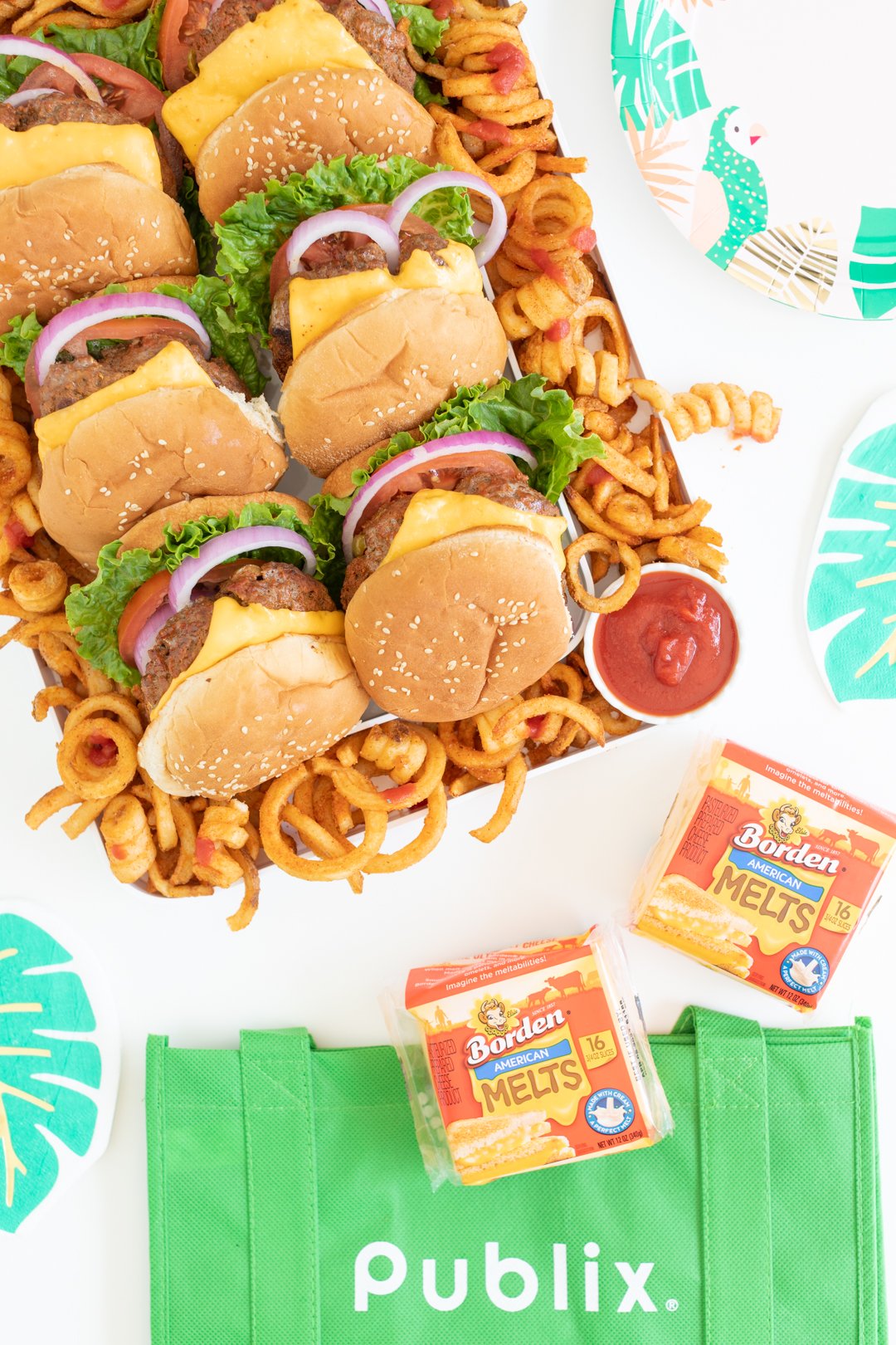 burger tray with curly fries shown with green publix reusable bag and packages of borden american melts