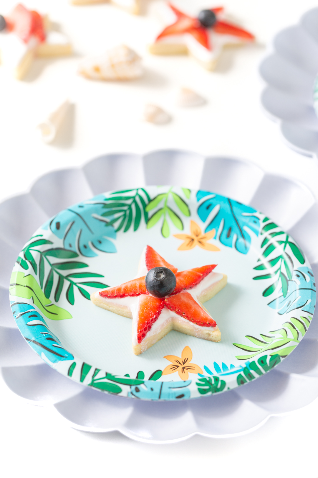 fruit topped star cookie on a tropical party plate