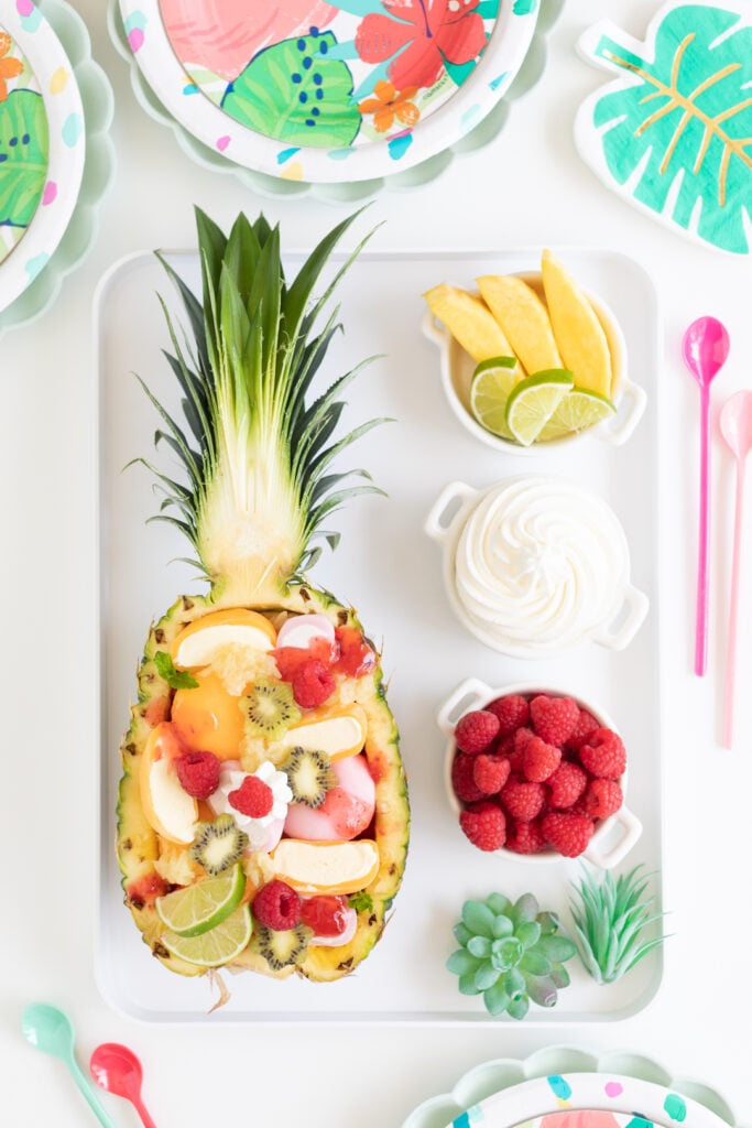 tray with halved pineapple sundae and toppings to add