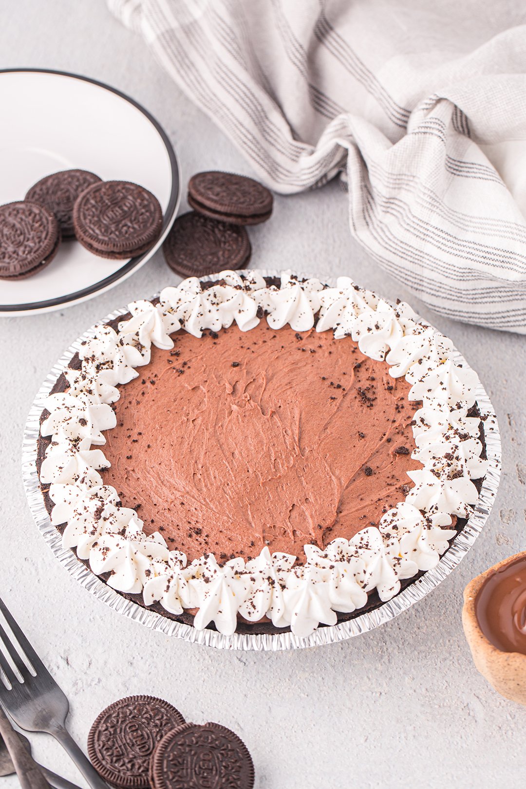 angled down over the top photo of whole no bake nutella pie with oreos and cocoa nearby