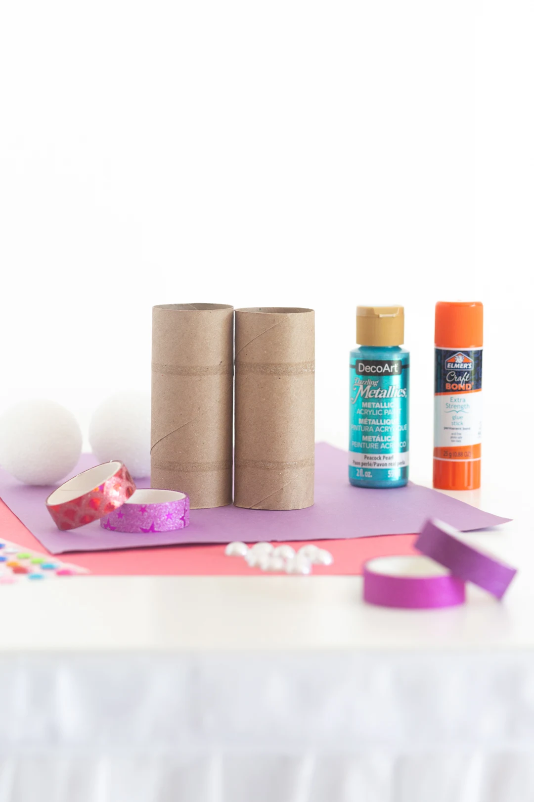 kid's craft microphone supplies including empty toilet paper rolls, paint, glue, construction paper
