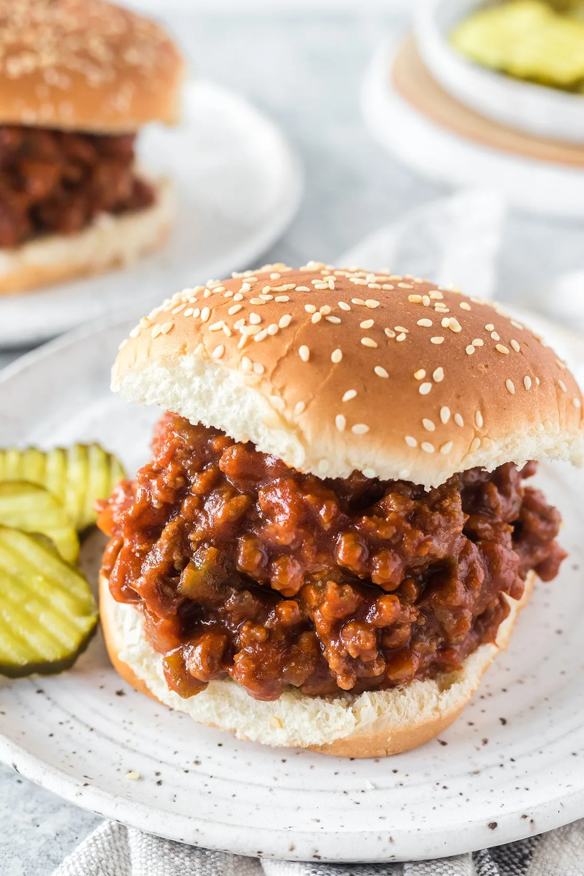 thick sloppy joes on buns with pickles.