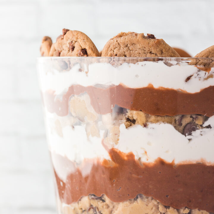 up close view of layered cookie dough trifle in a glass serving dish