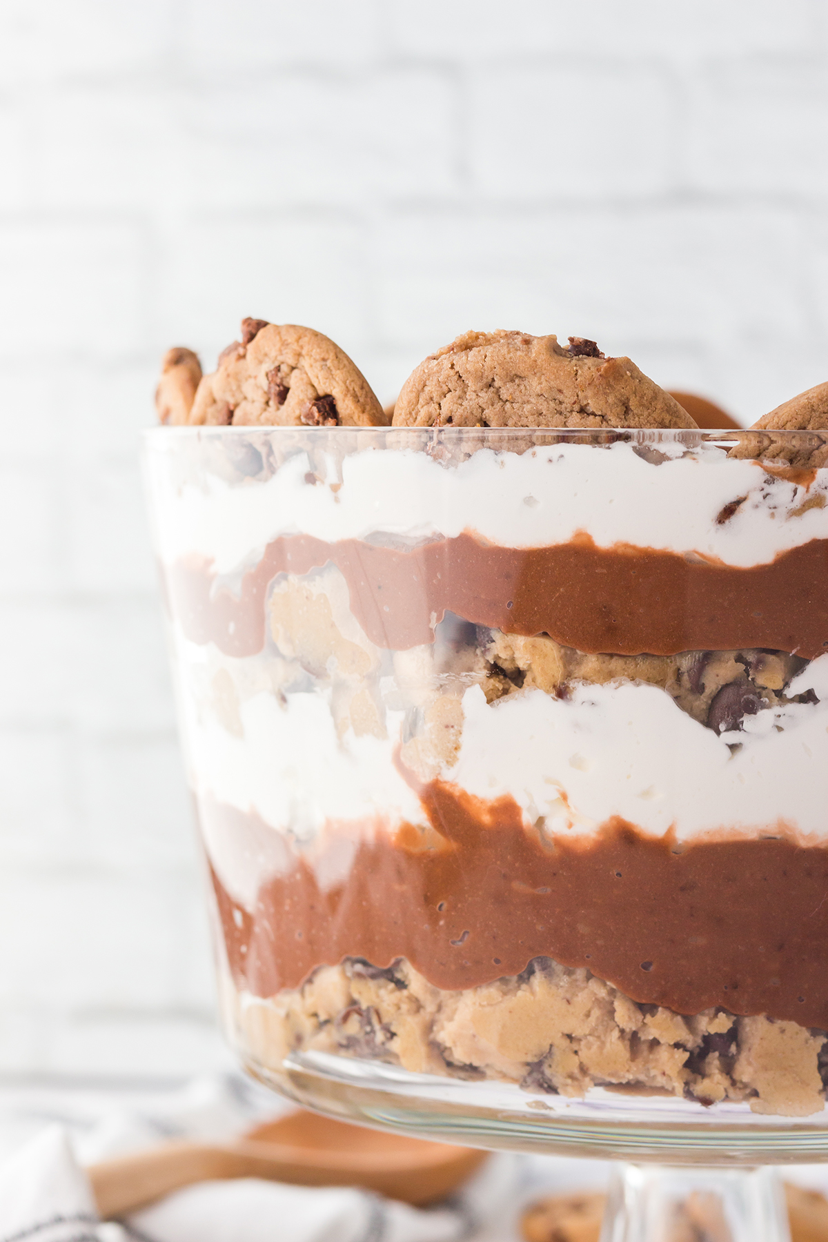 up close view of layered cookie dough trifle in a glass serving dish
