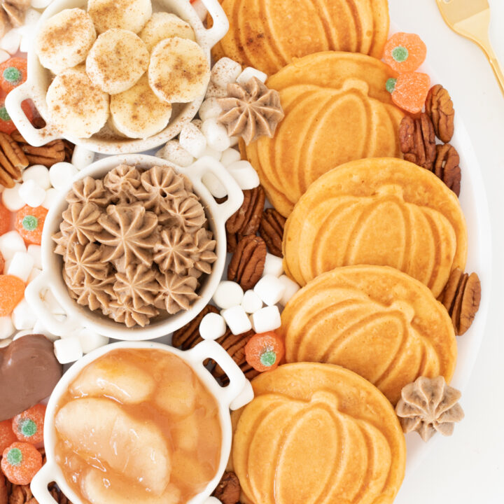 fall brunch board with pumpkin waffles, apple pie filling, pecans, mini marshmallows, banana slices