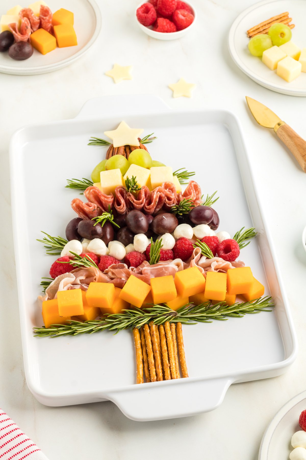 angled view of christmas tree charcuterie board with layers of chese, olives and fresh mozzarella.