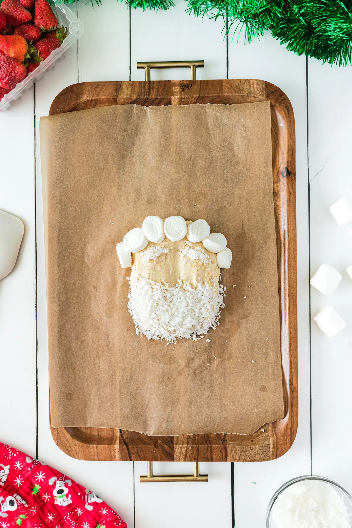 adding marshmallows to form santa hat on a shaped dip recipe