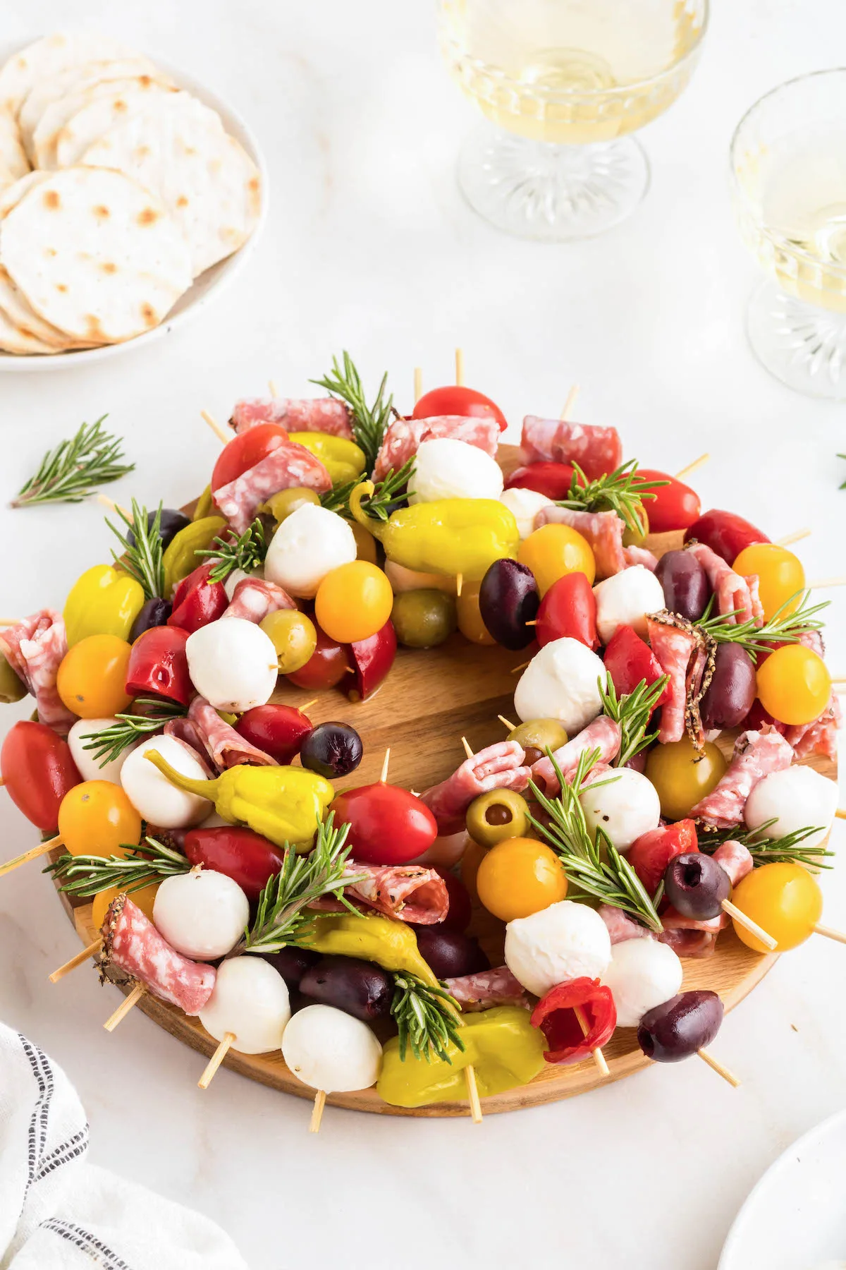 angled down photo of an antipasto wreath with grape tomatoes, olives, meats and fresh mozzarella balls