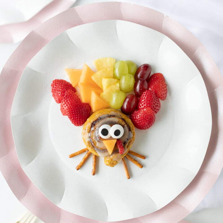 up close view of turkey made out of cinnamon roll and sliced fruits