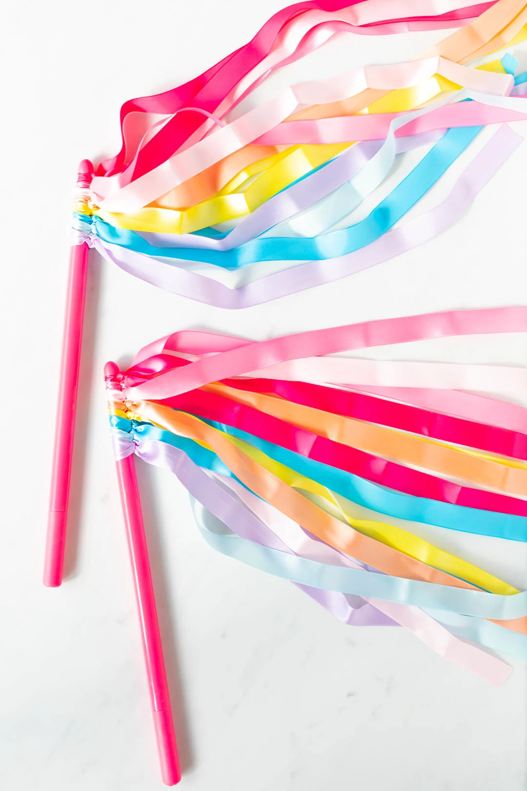 do it yourself dancing wands for kids. pink drumsticks with ribbons in rainbow colors