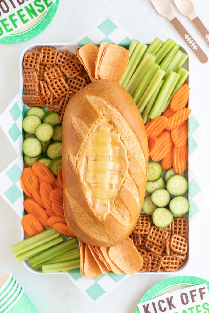 football shaped dip snack board for game day. loaded with pretzels, chips and veggies
