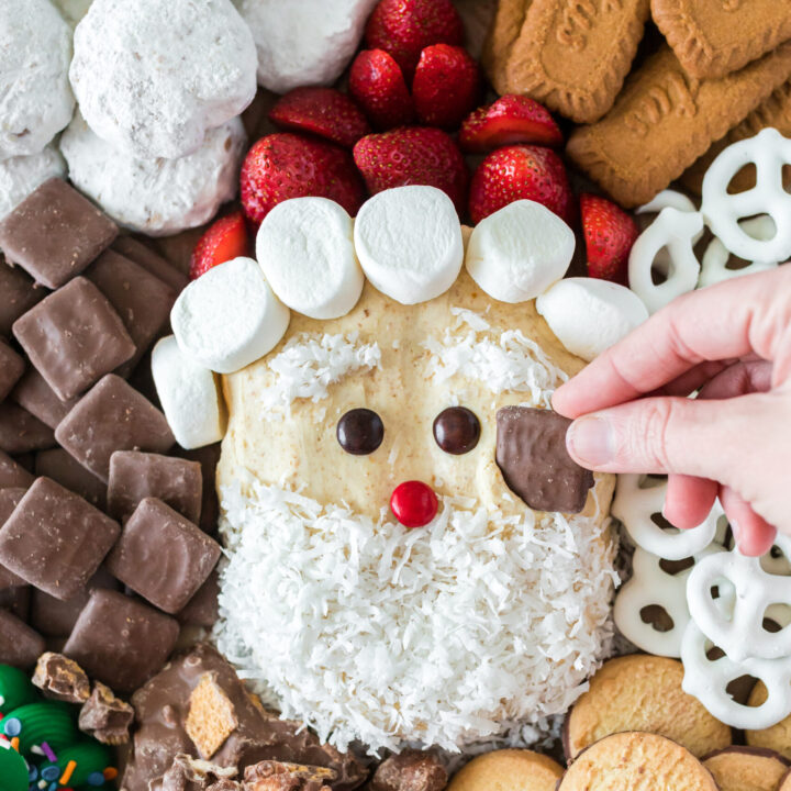 santa clause shaped dip on a tray with cookies, treats and pretzels