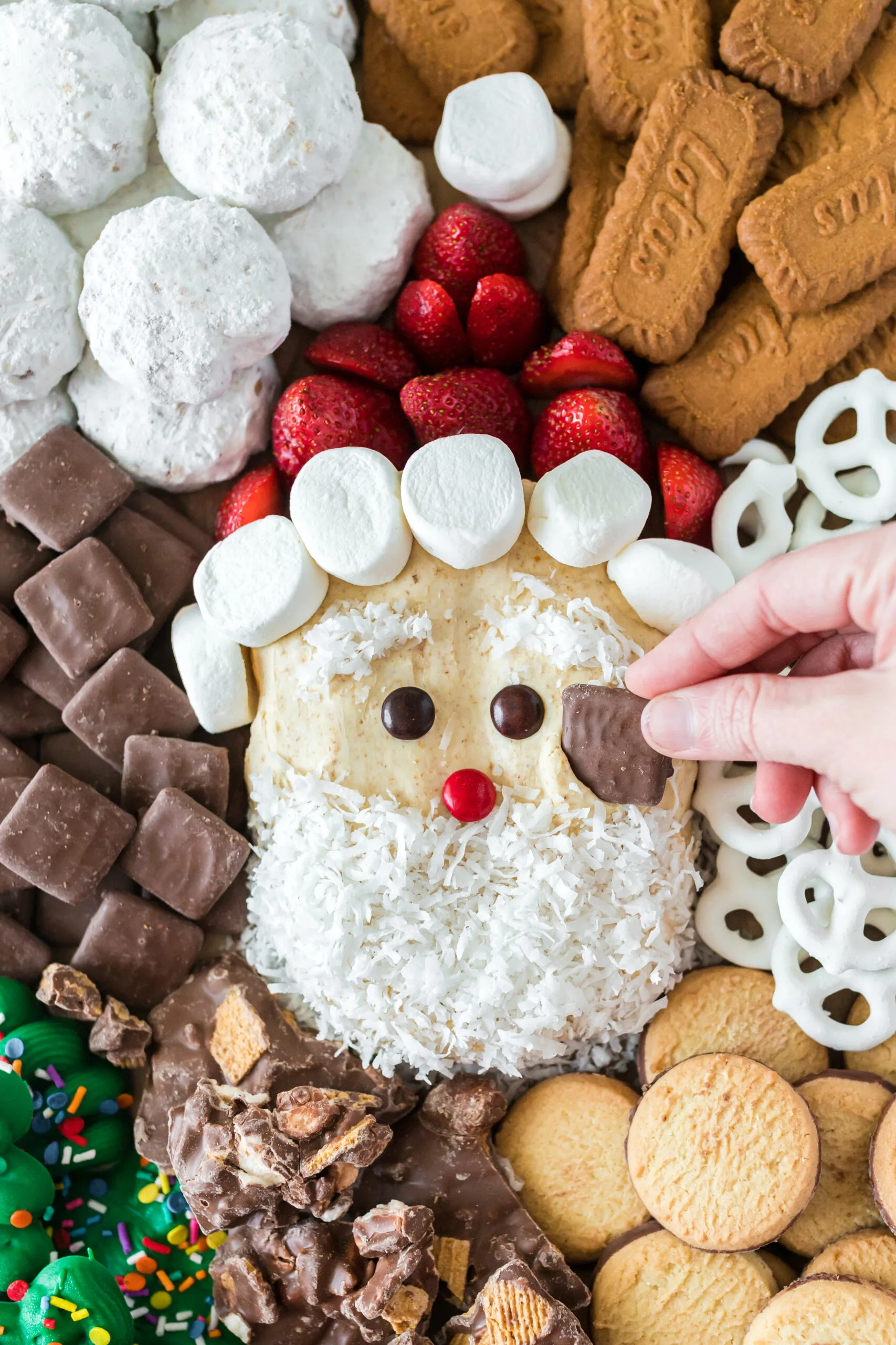 santa clause shaped dip on a tray with cookies, treats and pretzels