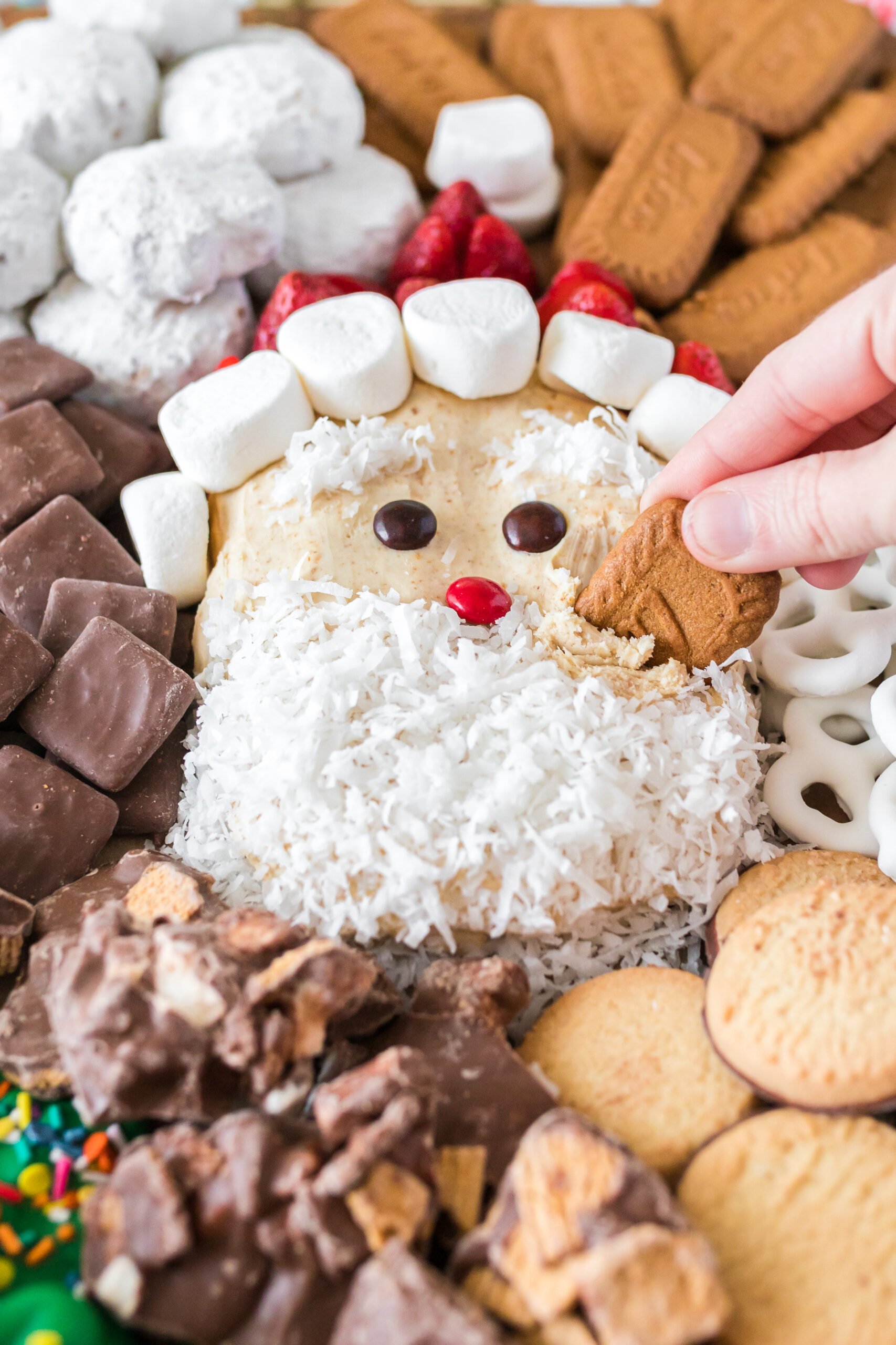 woman dipping cookie into santa clause shaped dip