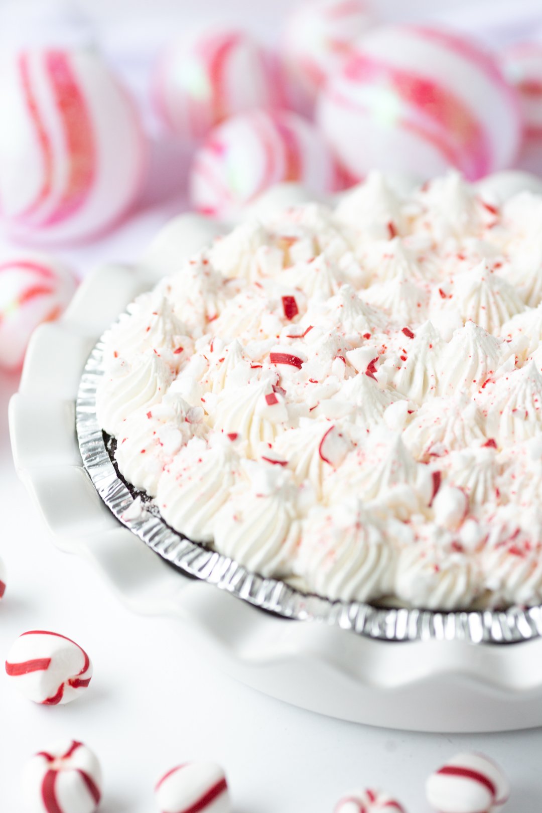 up close angled view of peppermint pie with crushed peppermint and pretty whipped cream