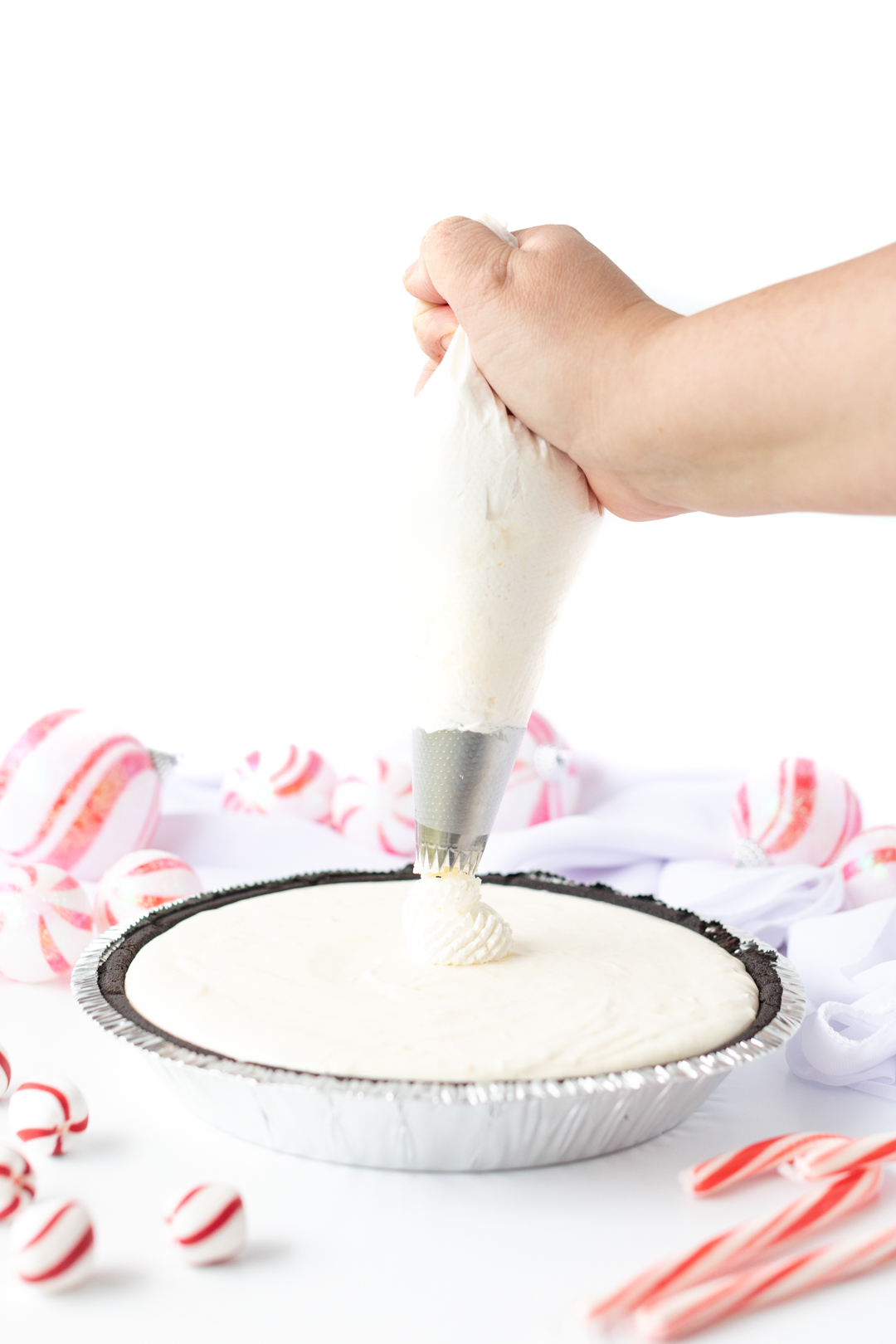piping whipped topping onto a pie using a pastry bag