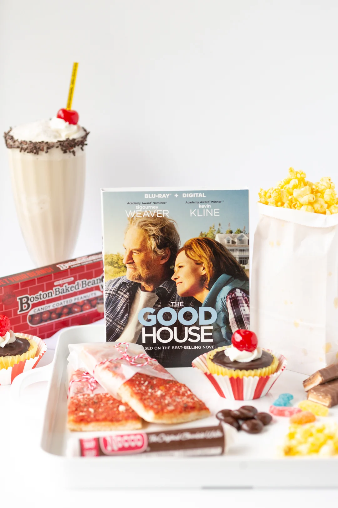 the good house snack tray with popcorn, drinks and snacks
