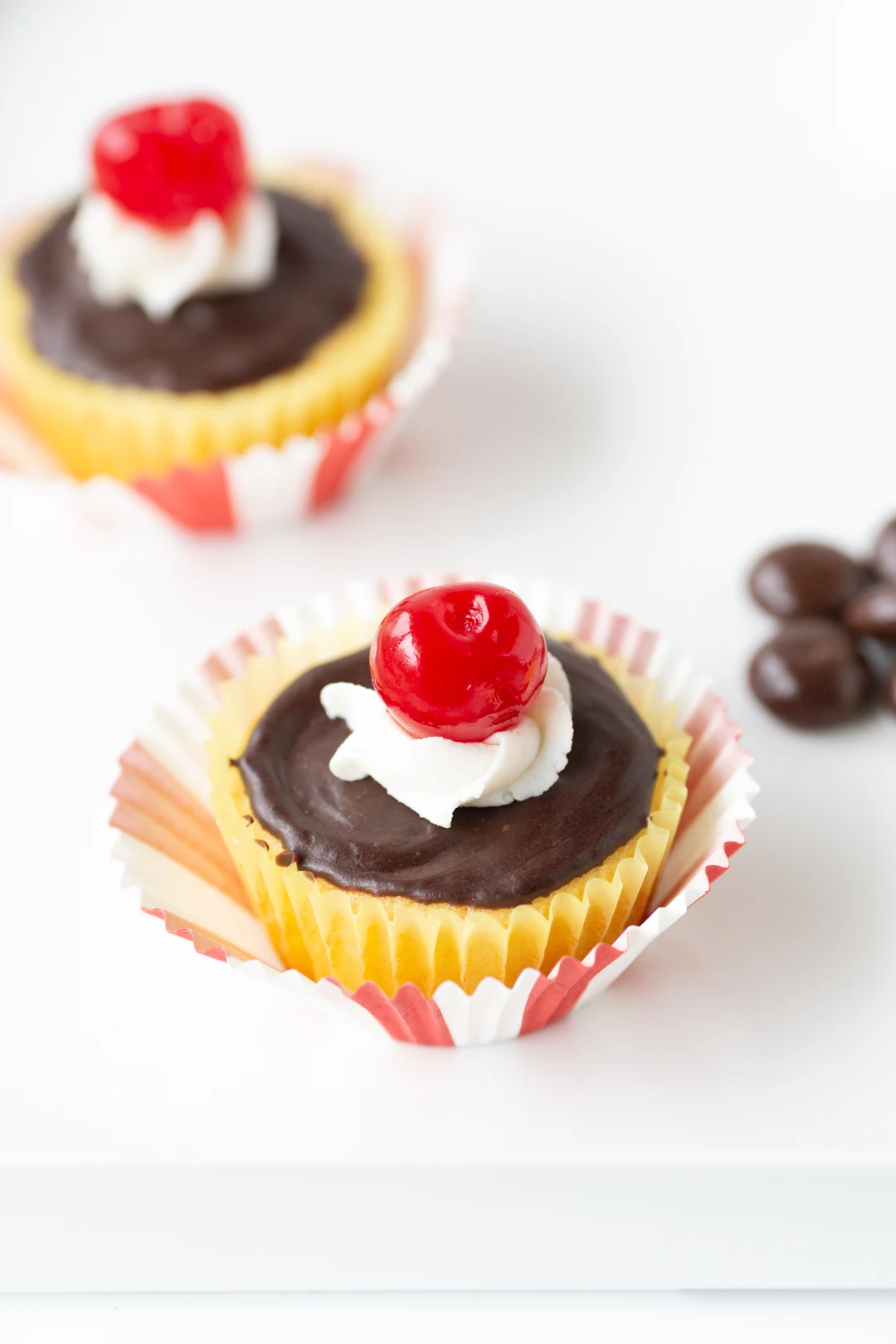 boston cream pie cupcakes with frosting and cherry on top