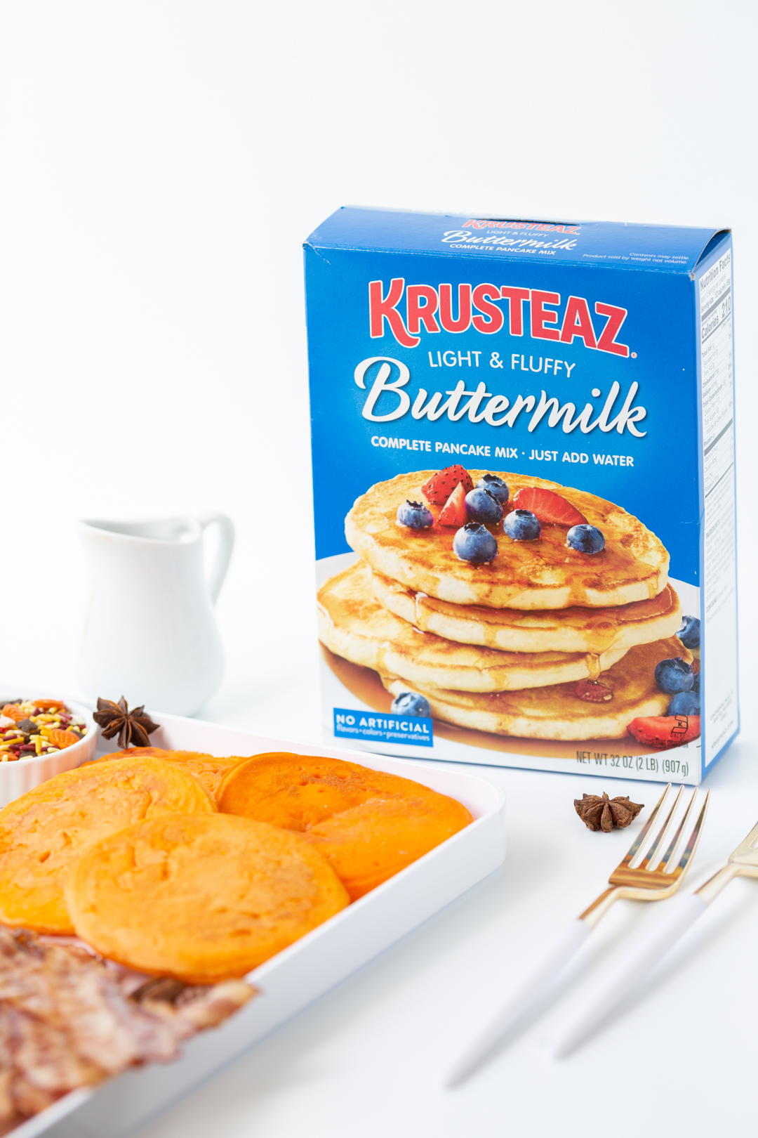krusteaz buttermilk pancake mix box sitting next to a pancake board