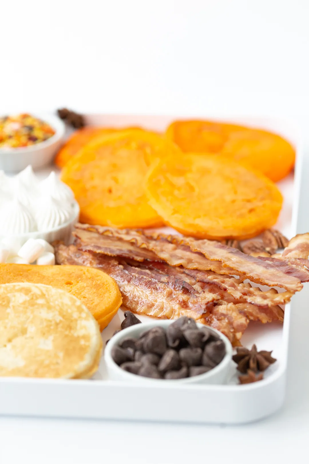 angled view of an orange tinted pancake brunch board that is perfect for thanksgiving