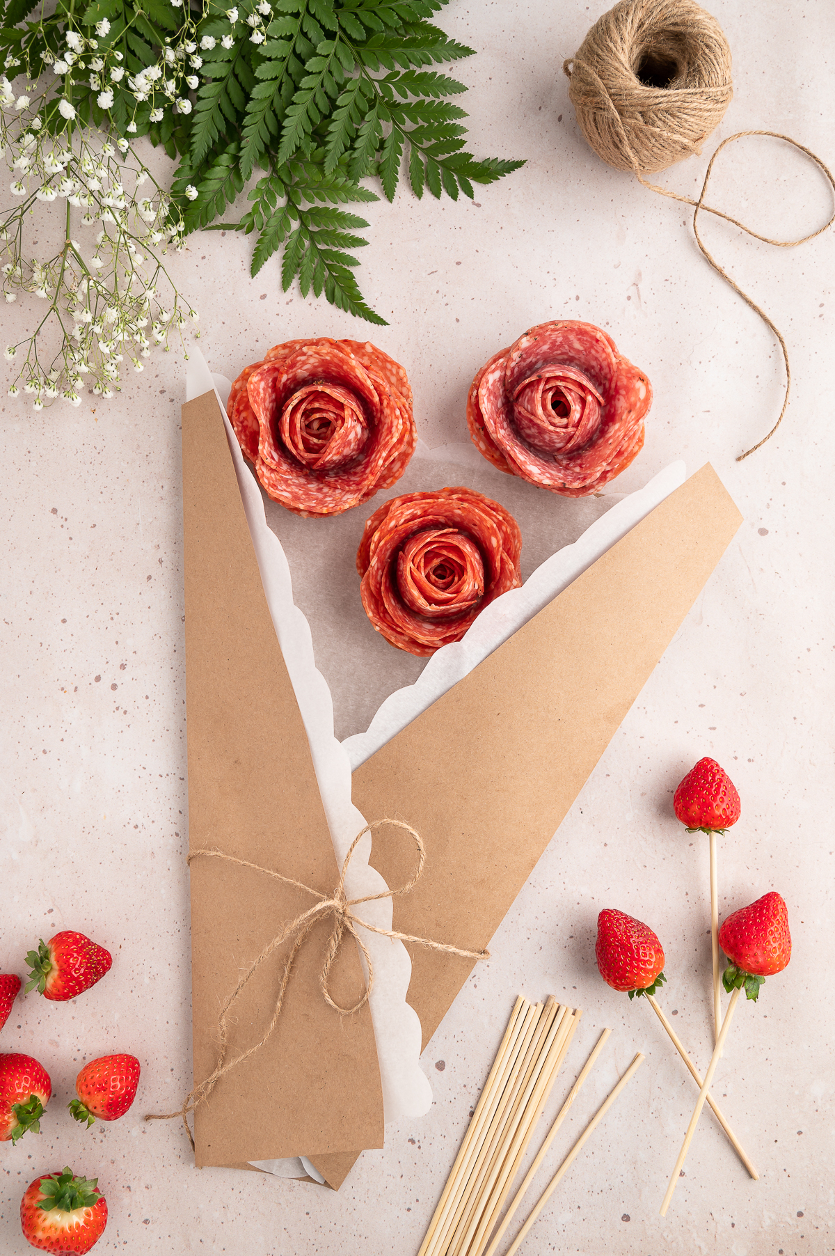 adding salami roses to floral bouquet wrap