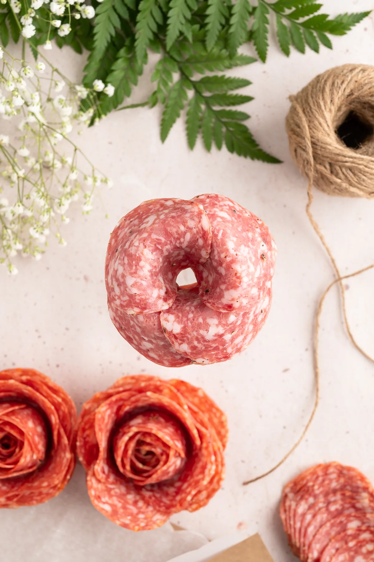 showing how to make a salami rose using a glass