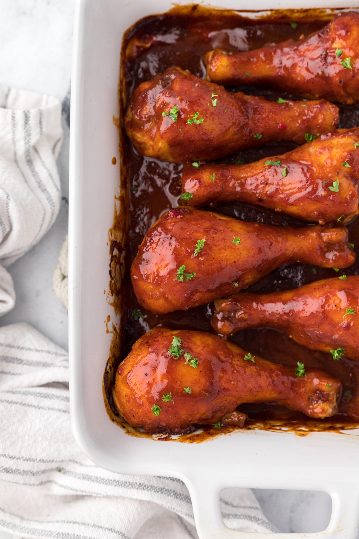 over top bbq baked chicken in white serving dishes