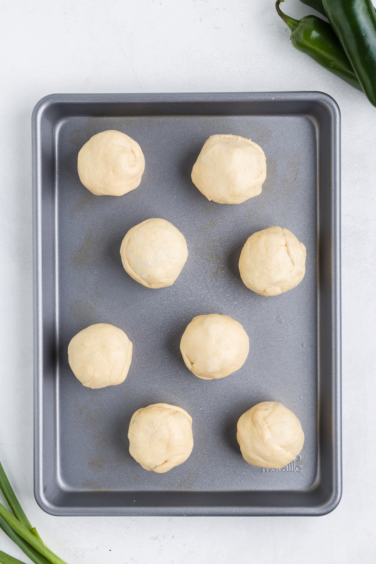 filled jalapeno rolls on a baking sheet