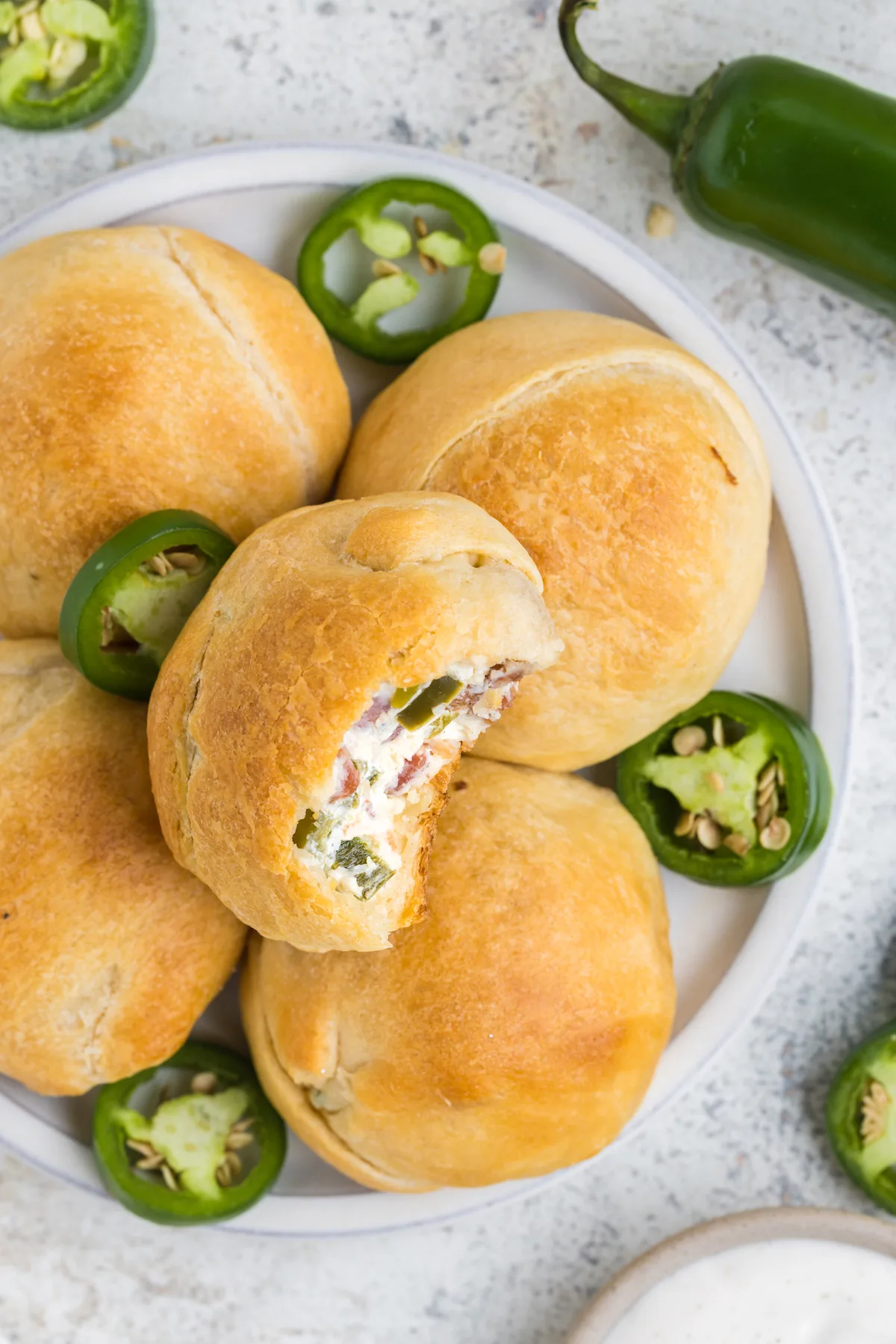 plate of jalapeno popper stuffed rolls with sliced jalapenos