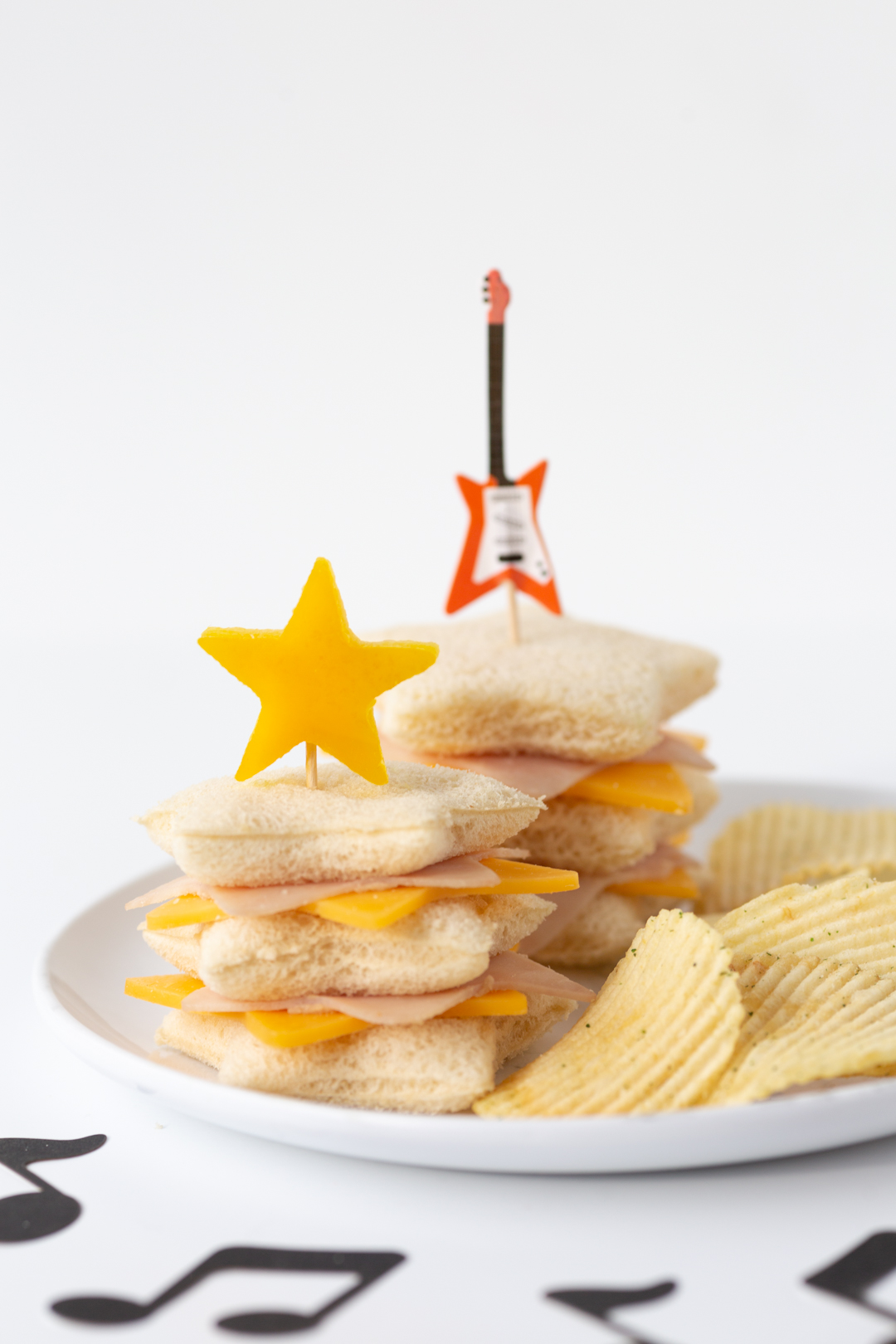 star shaped sandwiches on a plate and served with potato chips