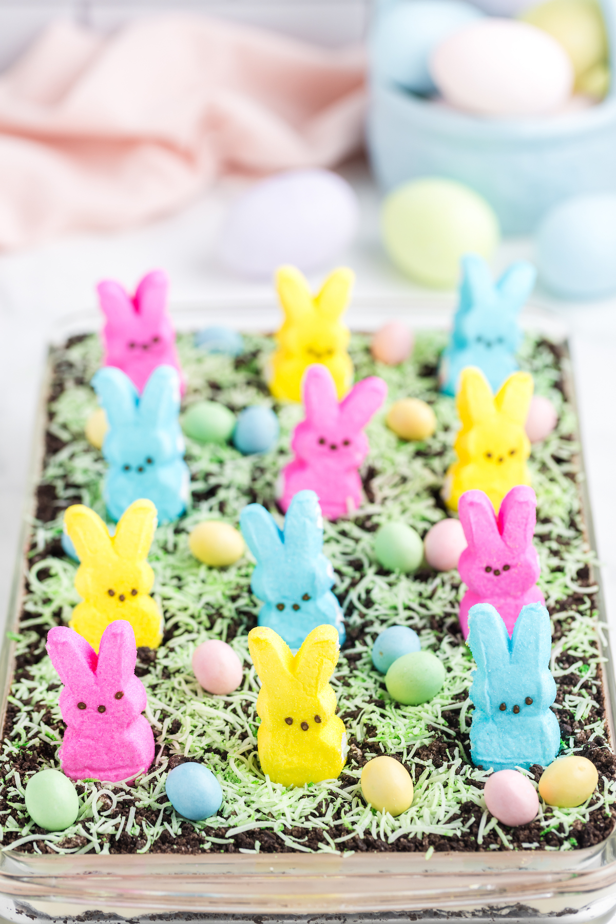 straight on view of a dirt cake decorated with Peeps and candy coated chocolate eggs.