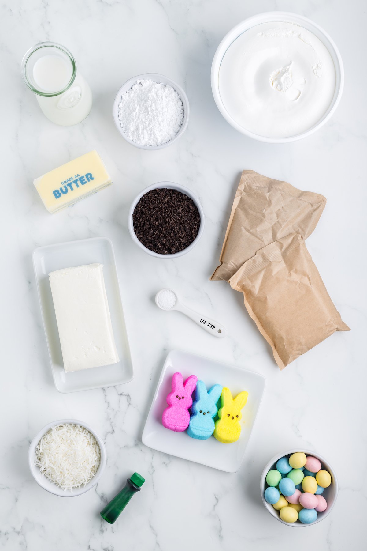 easter dirt cake ingredients flat lay photo including peeps, butter, cream cheese, instant pudding mix, cool whip.