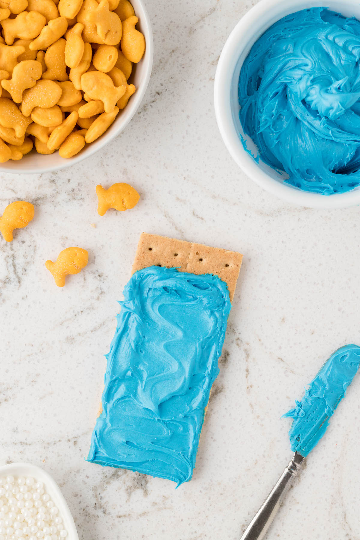 spreading blue frosting onto a graham cracker