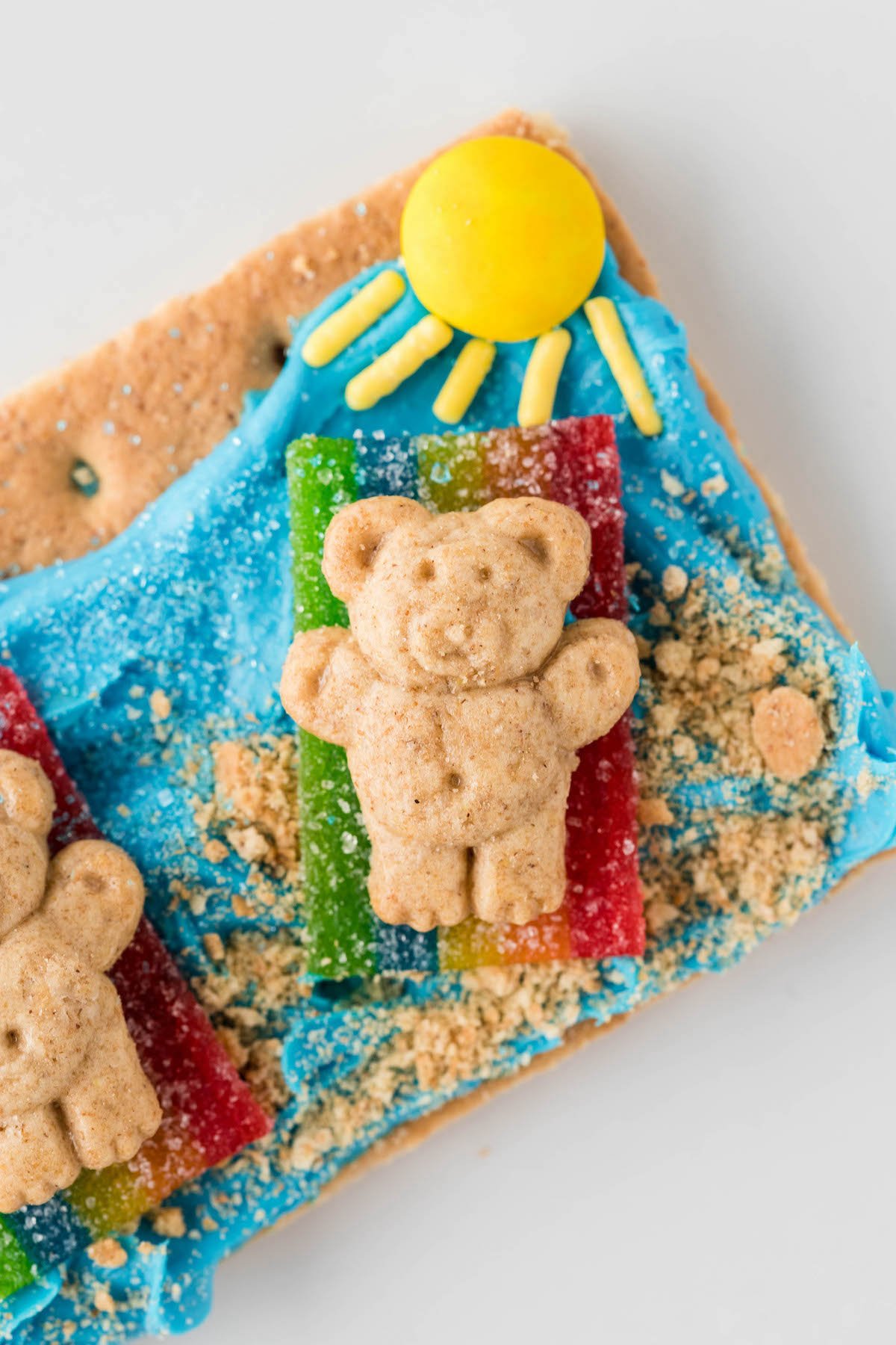 adorable teddy graham laying on a graham cracker beach. edible snack.
