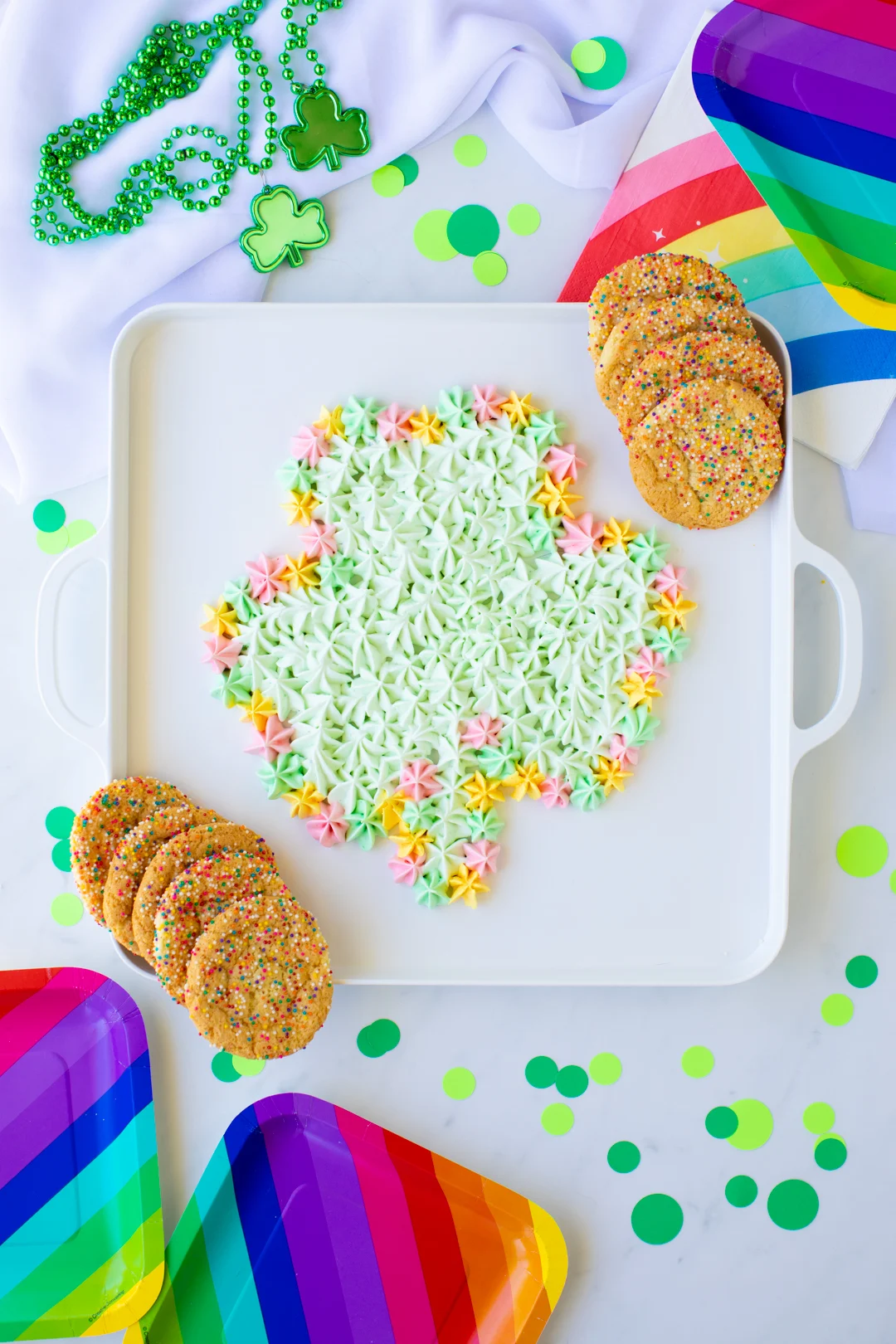 over the top flat lay of a pistachio shamrock shaped dessert dip set near st. patrick's day party decorations.