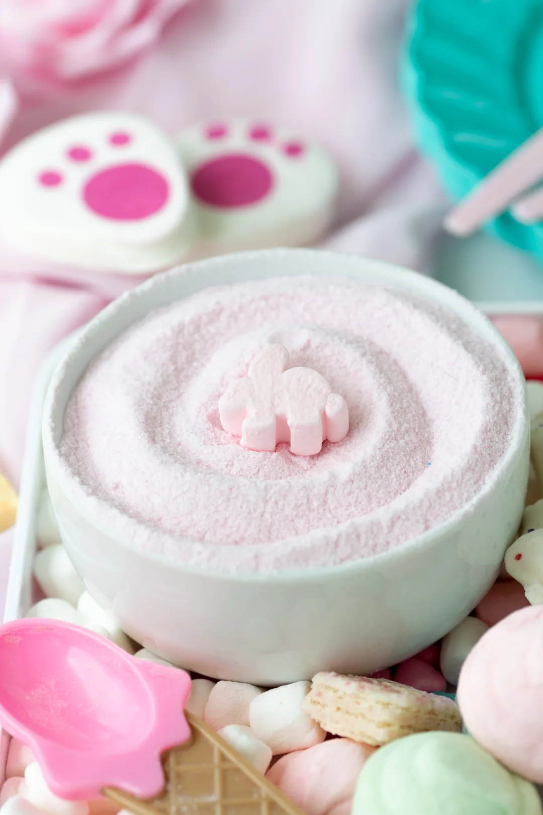 bowl of pink hot cocoa with a small pink bunny shaped marshmallow in the center.