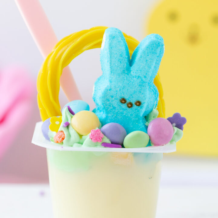 up close view of an easter basket pudding cup with peeps and m&ms.