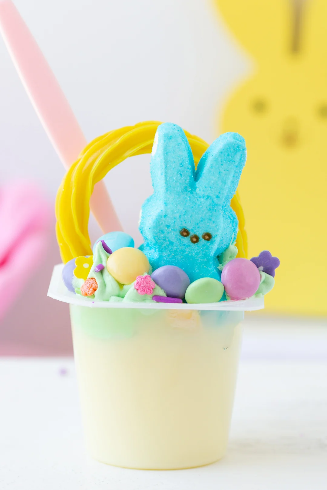 up close view of an easter basket pudding cup with peeps and m&ms.