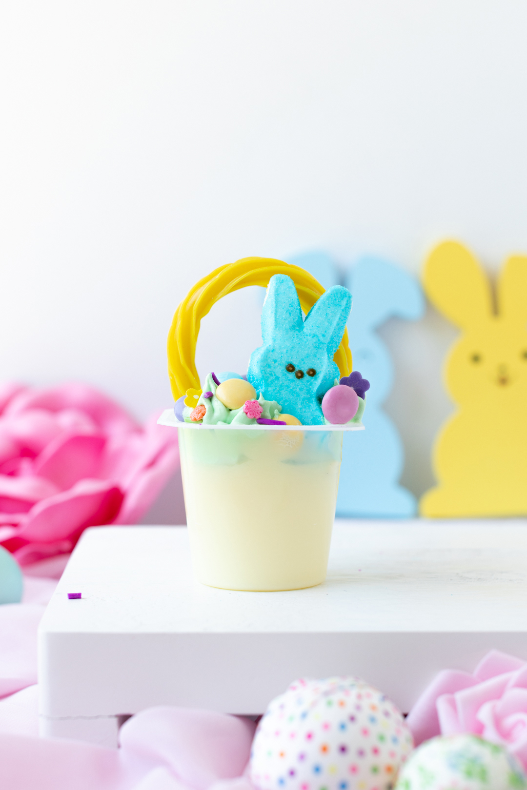 cute easter basket pudding cup using yellow licorice, peeps and pastel candies and green tinted whipped topping.