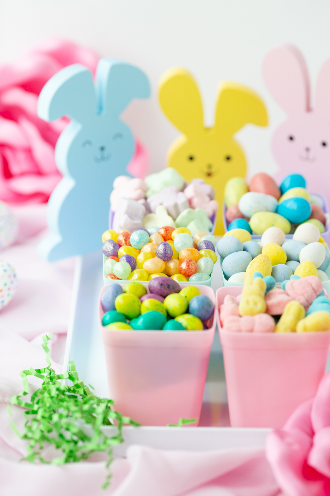 side view of easter candy in planters with wooden bunnies in the background
