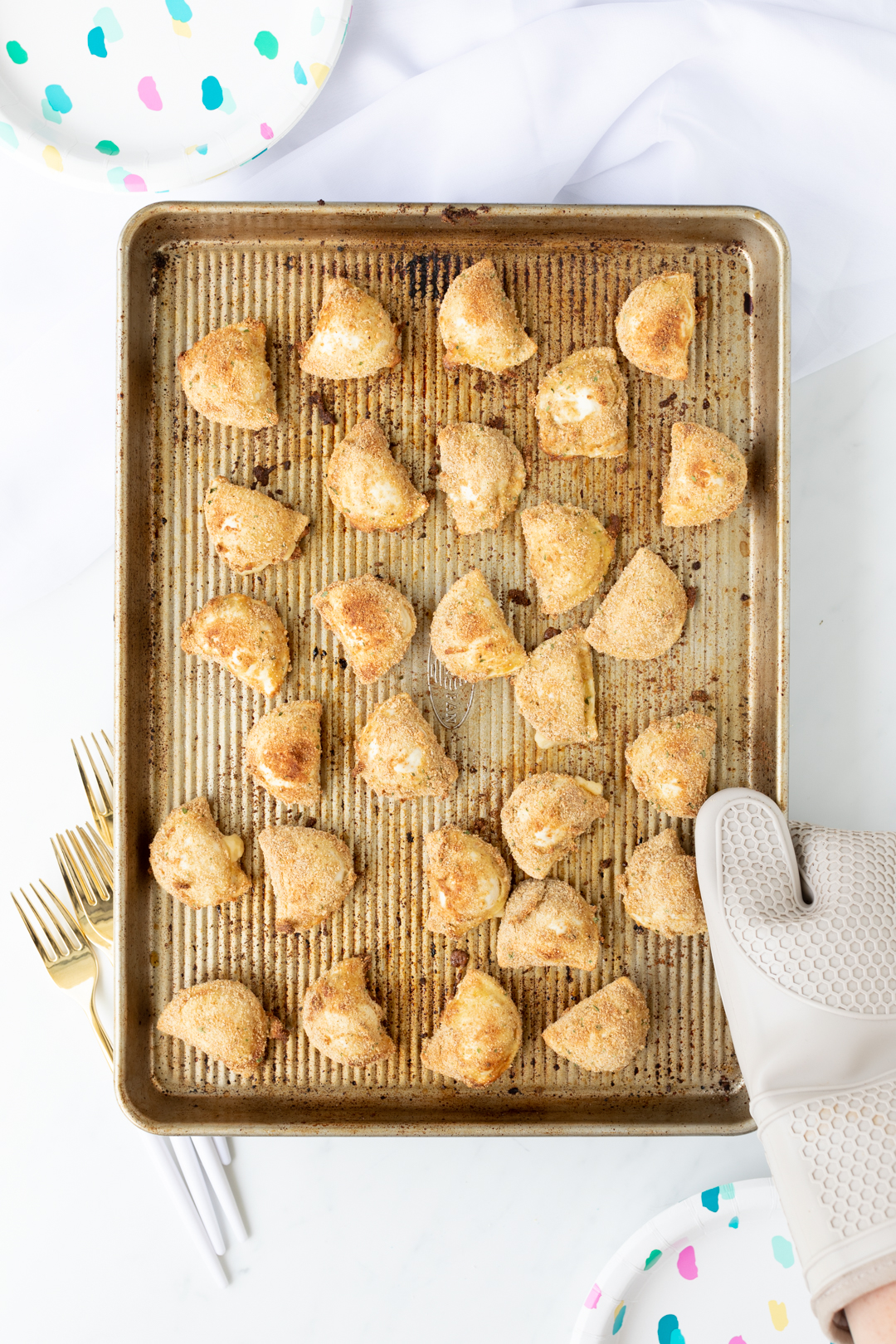 mini pierogies that are breaded and baked on a baking sheet